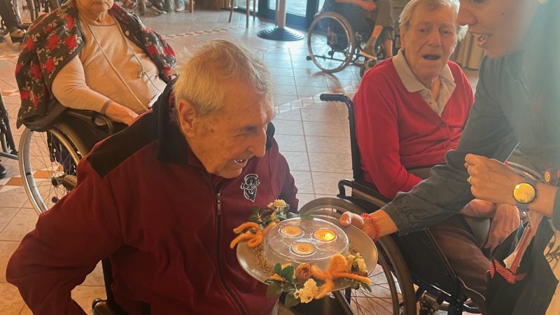 Uno dei festeggiati spegne le candeline a fine festa
